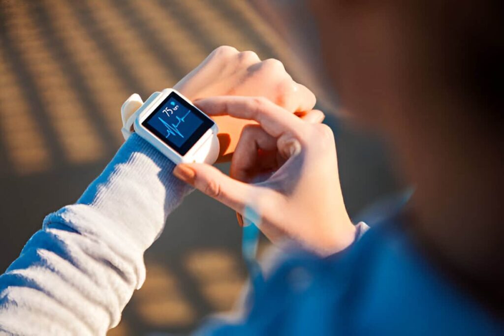 personne consultant son rythme cardiaque sur une montre connectée, suivi de la santé et de la performance